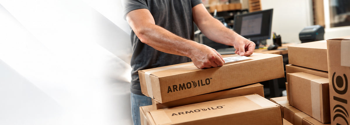 Armodilo team member applying a shipping label to boxed orders in the packing area