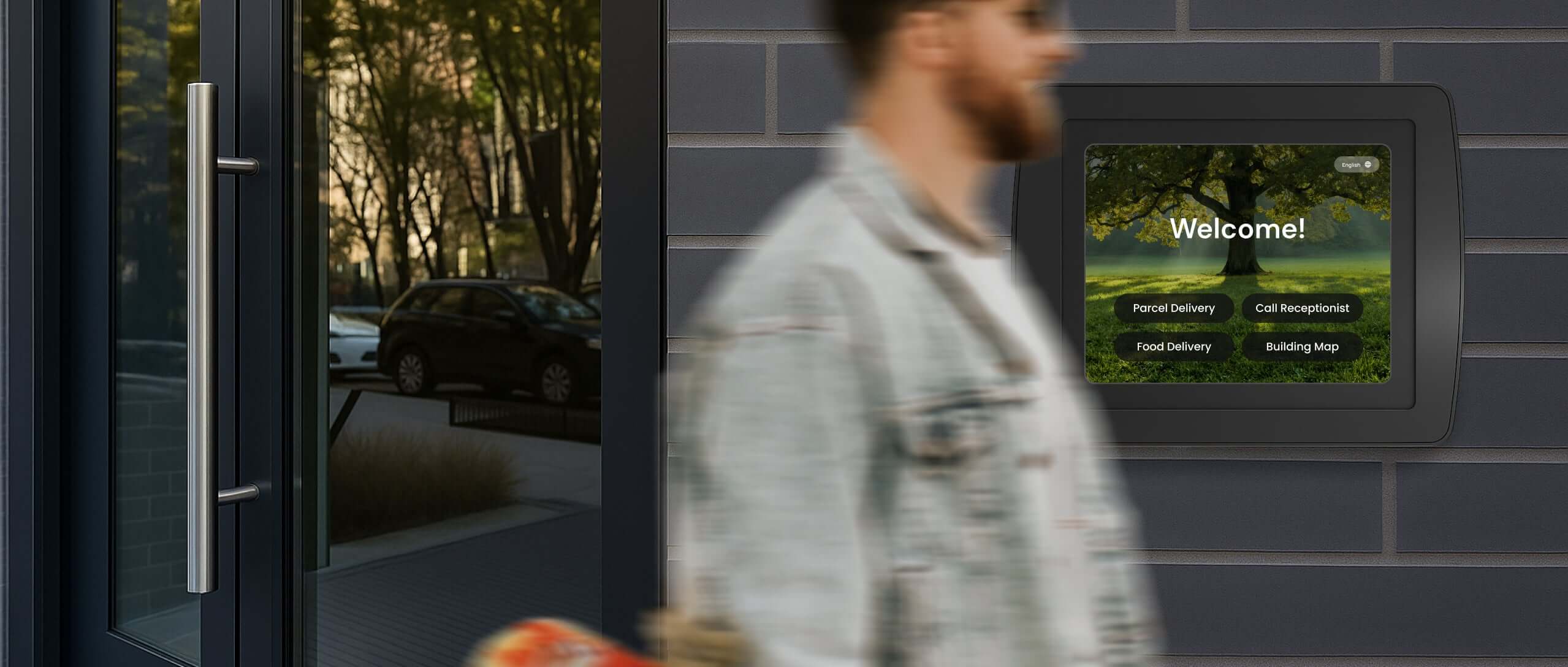 Outdoor wall mount tablet enclosure bundle installed by main entrance, with visitor walking past secure kiosk housing.